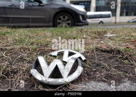 Berlin, Germany, broken grill grille emblem of a Volkswagen lies on the green strip of a street Stock Photo
