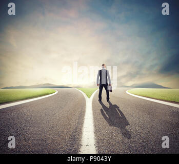 Businessman in front of a crossway must select the right way Stock Photo