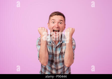 Portrait of young european man with overjoyed facial expression on pink colored background. Stock Photo