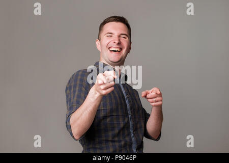 Handsome excited european young man smiling pointing fingers at you. Stock Photo