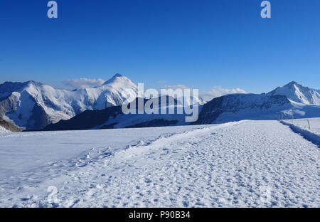 Snow path with spoors on the way from Mönchshut to Jungfrau train station in the Swiss Alps Stock Photo