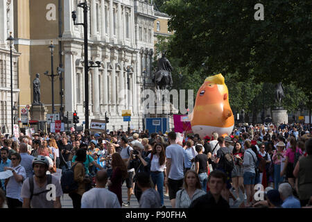 The Baby Trump balloon makes its way up Whitehall during the protest in central London against the visit of US President Donald Trump to the UK, on 13th July 2018, in London, England. Stock Photo