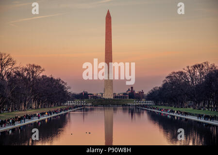 The Washington Monument and the Reflecting Pool in Washington DC during sunset.