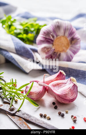 Garlic Cloves and Bulbs with rosemary salt and pepper on white marble ...