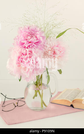 Three pink Peonies in glass jug Stock Photo