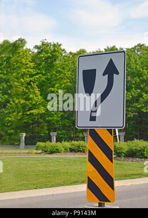 A road sign says there is an obstacle to go around up ahead Stock Photo