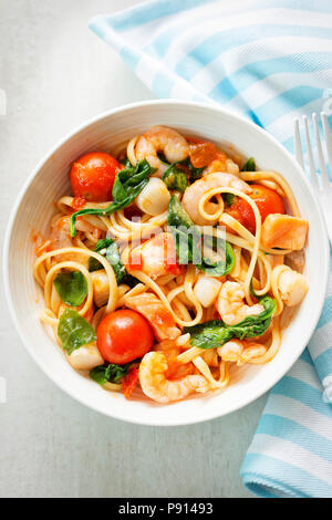 Seafood linguine with prawns, scallops and salmon, spinach and tomatoes
