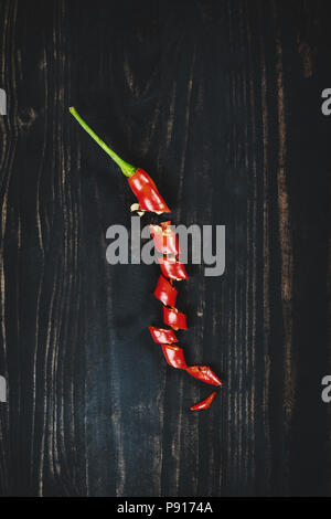 Red hot chilli pepper on black wood, top view Stock Photo