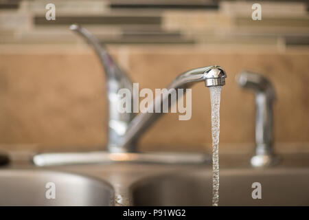 Getting a drink of water from the sink. View has shallow depth of field and is a head on view of a faucet Stock Photo