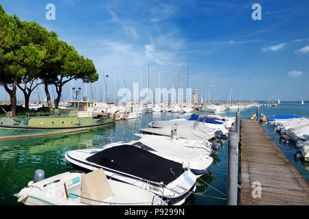 Small yachts in harbor in Desenzano del Garda on beautiful autumn day, Lombardy, Italy Stock Photo