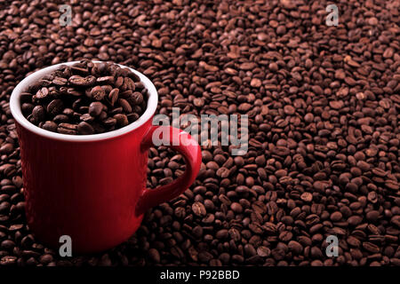 Red coffee mug filled with beans background Stock Photo