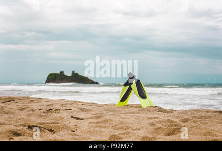 Two short yellow and black flippers balanced in the sand of Playa Cocles near Puerto Viejo, Costa Rica Stock Photo