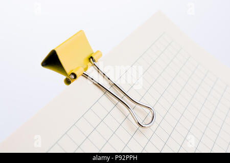 Colored paper clip on a checked notebook  page Stock Photo