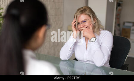 Candidate woman laughing during job interview in office Stock Photo