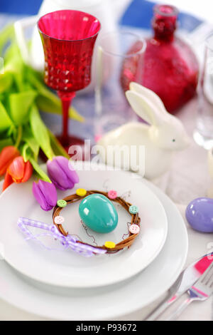 Beautiful table setting with crockery and flowers for Easter celebration. Glassware and cutlery for catered event dinner. Stock Photo