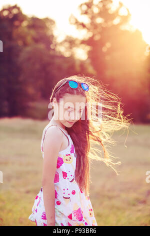 Beautiful Teen girl is dancing in the park at summer sunset Stock Photo