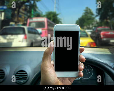 man using a smartphone while driving a car Stock Photo