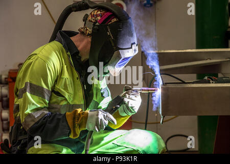 Welder wearing protective equipment welding