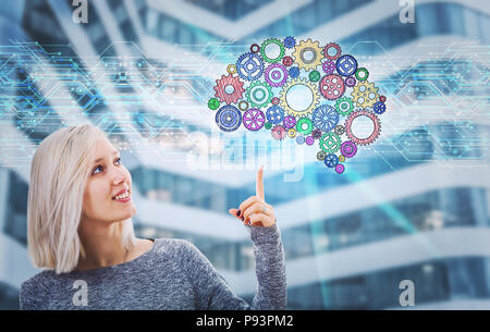 Portrait of smiling woman pointing finger up showing a gear brain hologram. Future technology artificial intelligence. Human logic and emotions concep Stock Photo