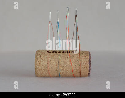 Threaded needles stuck in a wine cork Stock Photo