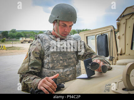 Army Reserve Private 1st Class Ian Ebow, a chemical, biological, radiological and nuclear (CBRN) specialist and native of Houston, Texas, assigned to the 340th Chemical Company, 450th Chemical Battalion, 209th Regional Support Group, 76th Operational Response Command, checks his notes on the front of a Humvee prior to participating in a daytime gunnery event at Fort Hood, Texas July 11.  Nearly 400 Army Reserve Soldiers from the 415th Chemical Battalion and the 209th Regional Support Group, 76th ORC are currently conducting a variety of gunnery related training at Fort Hood as part of exercise Stock Photo
