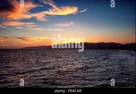 The sun setting over the mountains on the west coast at Santa Monica California and the Pacific Ocean. Stock Photo