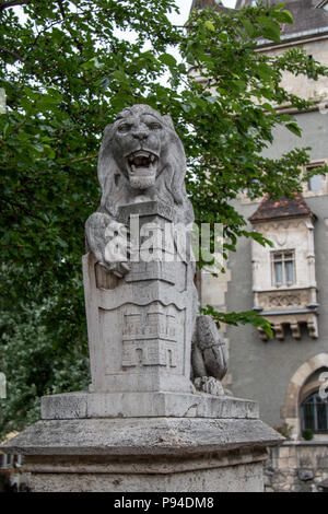 A statue of a lion with a crest on a shield in front of it near Vajdahunyad Castle in Budapest, Hungary. Stock Photo