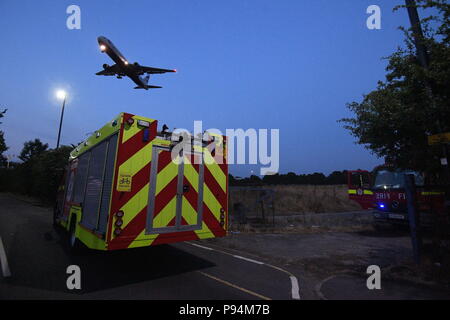 The London Fire Brigade battling a grass fire near Heathrow airport the size of four football pitches. Fifteen fire engines and 97 firefighters were deployed to tackle the blaze in Feltham, west London. Stock Photo