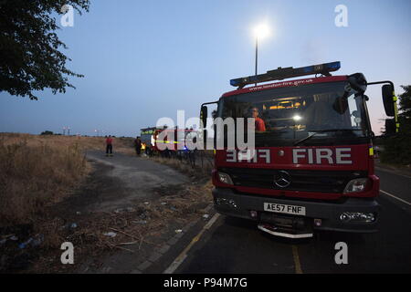 The London Fire Brigade battling a grass fire near Heathrow airport the size of four football pitches. Fifteen fire engines and 97 firefighters were deployed to tackle the blaze in Feltham, west London. Stock Photo