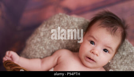 Portrait of cute baby girl laying in basket above top view Stock Photo