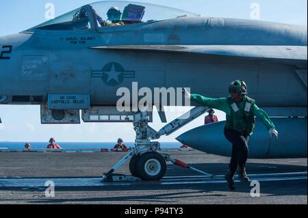 180712-N-OY799-0120  PHILIPPINE SEA (July 12, 2018)  Aviation Boatswain's Mate (Equipment) Airman Olivia Fobbs, from Los Angeles, clears the launching area of an F/A-18E Super Hornet assigned to Strike Fighter Squadron (VFA) 195 on the flight deck of the Navy's forward-deployed aircraft carrier, USS Ronald Reagan (CVN 76). Ronald Reagan, the flagship of Carrier Strike Group 5, provides a combat-ready force that protects and defends the collective maritime interests of its allies and partners in the Indo-Pacific region. (U.S. Navy photo by Mass Communication Specialist 2nd Class Kenneth Abbate/ Stock Photo