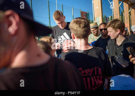 Berlin, Germany. 14th July, 2018. Kristaps Porzingis, power forward with the New York Knicks, giving autographs during the streetball tournament at the Friedrich-Ludwig-Jahn-Sportpark. Credit: Gregor Fischer/dpa/Alamy Live News Stock Photo