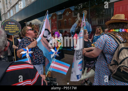 London, UK. 14th July 2018. People wait for  Croydon Pride procession to start. Several hundred people paraded through the centre of Croydon on their way to the third Croydon Pridefest, sponsored by Croydon Council, in Wandle Park. Many were in colourful dress and there were banners, flags, placards, posters and unicorns. The free festival aims to promote LGBT+ equality and diversity in Croydon, and is London's second largest Pride festival. Following the disruption by anti-Trans activists at London Pride, the parade gave the Trans People Across London (TRANSPALS) banner a prominent position b Stock Photo