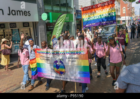 London, UK. 14th July 2018. Rainbows Across Borders, a group which supports LGBT asylum seekers and the Communication Workers Union at the read of the Croydon Pride procession. Several hundred people parade through the centre of Croydon on their way to the third Croydon Pridefest, sponsored by Croydon Council, in Wandle Park. Many were in colourful dress and there were banners, flags, placards, posters and unicorns. The free festival aims to promote LGBT+ equality and diversity in Croydon, and is London's second largest Pride festival. Following the disruption by anti-Trans activists at London Stock Photo