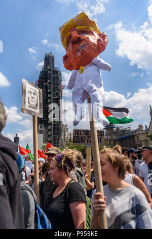 London, UK. 14th July 2018. Anti-fascist network protesters who have marched from the International Brigade Memorial on the South Bank across Westminster Bridge move into Parliament Stree, one carrying a large caricature of Donald Trump on a pole. They had come in protest against the 'Free Tommy' protests against the jailing of Tommy Robinson for contempt of court for actions which could have stopped the trial of a grooming gang - an offence to which he pleaded guilty. Peter Marshall/Alamy Live News Stock Photo