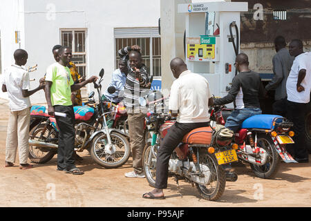 Kamdini, Uganda - street scene. Motorcyclists wait to be refueled at a gas station of a gas station.