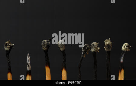 row of burned matches isolated on black background Stock Photo