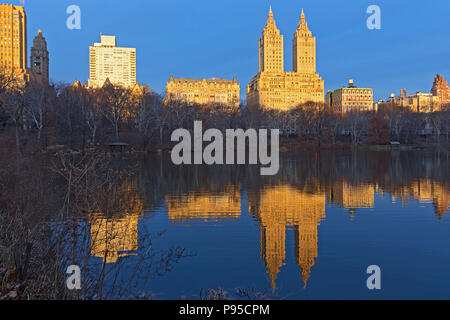 A view on Manhattan buildings from the Central Park at sunrise in winter. The Central Park landscape near the water, New York, USA. Stock Photo