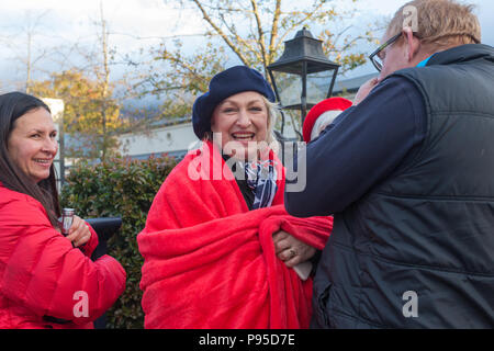 blonde haired mature woman smiling wearing beret and red blanket around shoulders with friends Bastille day 14th July 2018 Franschhoek, Cape Winelands Stock Photo