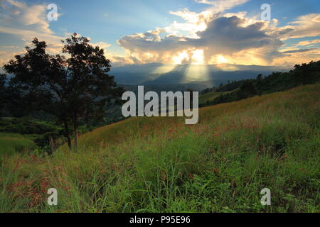 Dramatic god lights passing through clouds and shining on mountain ranges. warm light shower. God hope and dream concept Stock Photo