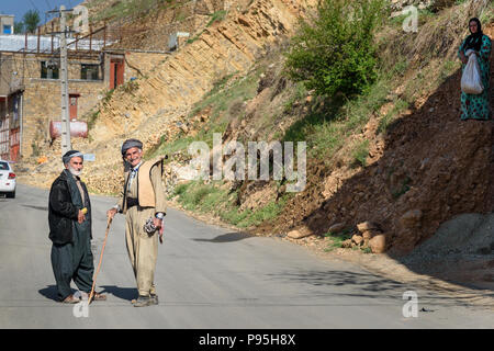 Howraman, Kurdistan Province, Iran - April 5, 2018: Kurdish men in traditional clothing on the street of Howraman village or Uraman Takht in Zagros Mo Stock Photo