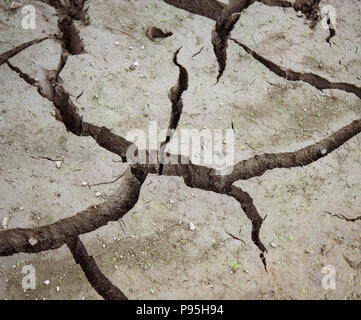 Dry cracked mud at the bottom of dried reservoir Stock Photo