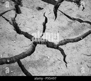 Dry cracked mud at the bottom of dried reservoir Stock Photo