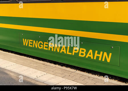 Yellow and green Wengernalpbahn (Wengernalp Railway) name on the side of a railway carriage in Grindelwald, Jungfrau region, Bernese Oberland Stock Photo