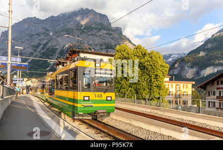 Yellow and green Wengernalpbahn (Wengernalp Railway) train to Grund in Grindelwald station, Jungfrau region, Bernese Oberland, Switzerland Stock Photo