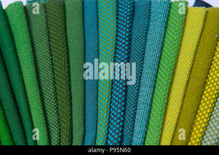 Colourful detailed fabrics lay out side by side on display to differentiate the colours and texture. Stock Photo