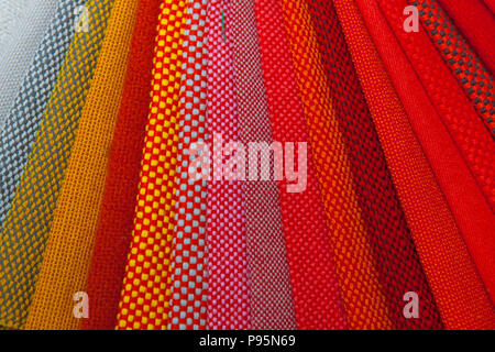 Wide range of colourful red tone fabrics sample collection lay out beautifully to see the details. High quality textiles design. Stock Photo