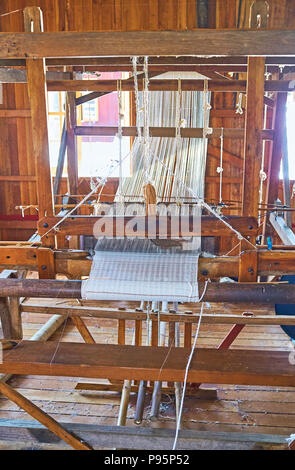 The old handloom in workshop with example of lotus fabric, created from the local handmade yarn, Inpawkhon, Inle Lake, Myanmar. Stock Photo