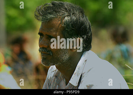 Indian farmer worker sitting outside on paddy field, nature background Stock Photo