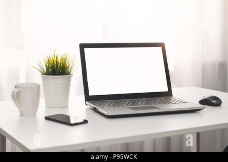 bright white workplace with laptop on the table in the room Stock Photo
